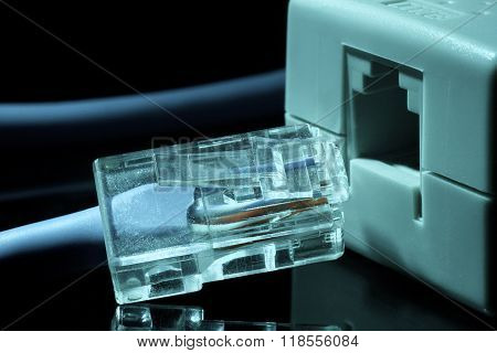 Twisted pair (patch cord) blue network Internet cable in blue tones on a black background is inserte
