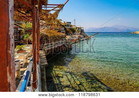 MATALA, CRETE, GREECE - AUGUST 20, 2013: People are swimming and sunbathe at Matala beach on Crete island. View from Akuna Matata tavern.