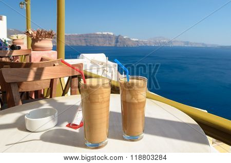 Ice coffee (frape) at balcony view on caldera