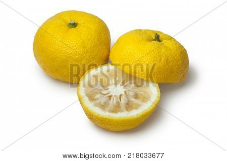 Pair of fresh yellow whole and half Japanese Yuzu on white background