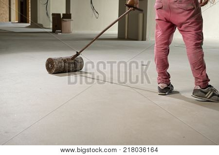 Manual worker pressing vinyl floor with pust roller.

