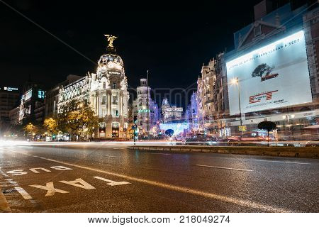 Madrid, Spain - December 8, 2017: Gran Via and Alcala streets in Madrid at night on Christmas time. Long exposure shot with light trails of traffic and blurred people