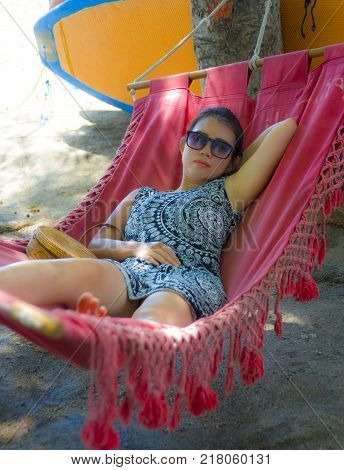 young pretty happy Asian Chinese woman lying lazy on beach hammock sun bed relaxed and cheerful in Summer holiday trip enjoying vacation in tourism and travel concept