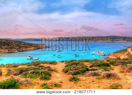 Beautiful landscape of Blue Logoon of Malta with turquoise water and colorful sky at sunset