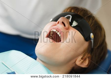 Process Of Preparing And Installing Dental Ceramic Crown. Male Professional Dentist And Female Assis