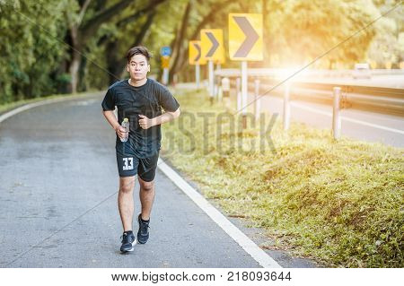 Active healthy runner jogging outdoor. Dinking water.