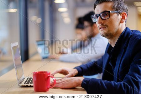 Young independent speacialists in coworking office.
