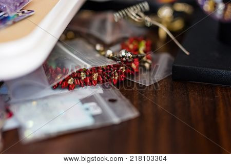 a pointsetta bracelet peeking out from under a pile of projects