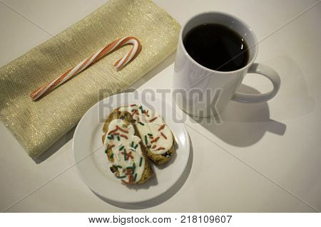 Decorated Cookies a cup of coffee and a candy cane on a napkin all on white surface.