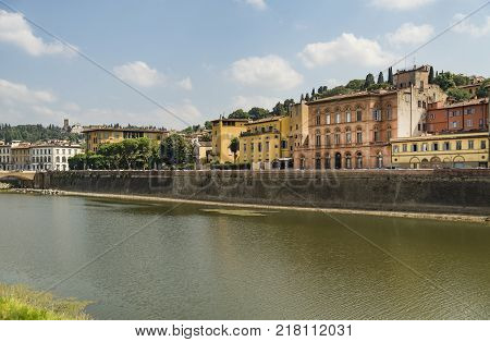 Scenic view of the Lungarno at historic center of Florence, Italy. Facades of old medieval houses on waterfront of the Arno River. Florence is a popular tourist destination of Europe.
