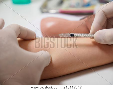 A physician holds a syringe needle above a diabetic patient's arm after an insulin injection. Healthcare and metabolic syndrome concept.