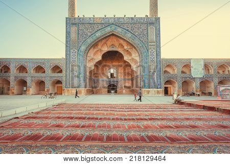 ISFAHAN, IRAN - OCT 14, 2017: Persian carpets at the entrance of the historical iranian mosque with artworks on October 14, 2017. The 3rd largest city of Iran Isfahan is an example of Islamic culture