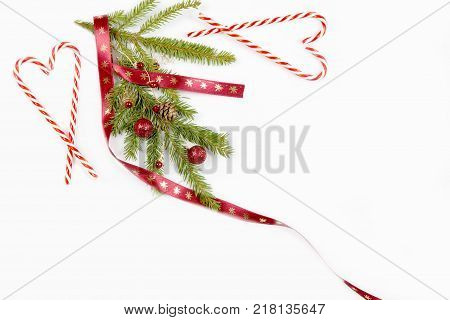 Christmas holiday composition. Festive creative pattern, xmas red decor holiday ball with Christmas candy canes, gift, snowflakes, christmas tree on white background. Flat lay, top view