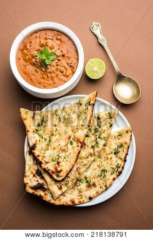 Dal makhani or dal makhni is a popular food from Punjab / India made using  whole black lentil, red kidney beans, butter and cream and served with garlic naan or Indian bread or roti