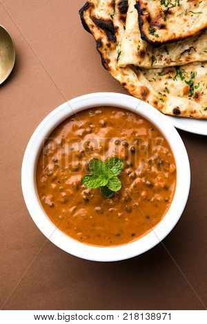 Dal makhani or dal makhni is a popular food from Punjab / India made using  whole black lentil, red kidney beans, butter and cream and served with garlic naan or Indian bread or roti