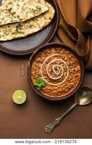 Dal makhani or dal makhni is a popular food from Punjab / India made using  whole black lentil, red kidney beans, butter and cream and served with garlic naan or Indian bread or roti