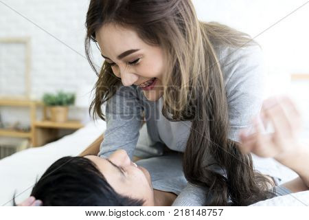 Close up young asian couple in love hug each other on the white bed in bedroom. Romantic couple enjoying in moments of happiness. Love and enjoy dating romance Lifestyle concept