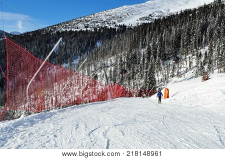 Jasna Slovakia - December 1 2017: Skiers on the of the mountain and the fence-grid on the south side of Mount Chopok on a sunny day in the ski resort Jasna Low Tatras Slovakia.