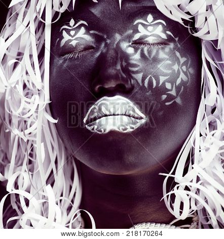 creative makeup like Ethiopian mask, white pattern on black face close up, halloween horror, fashion style print