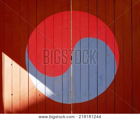 A symbol of Korea's iconic Taegeuk mark drawn on the old door.
