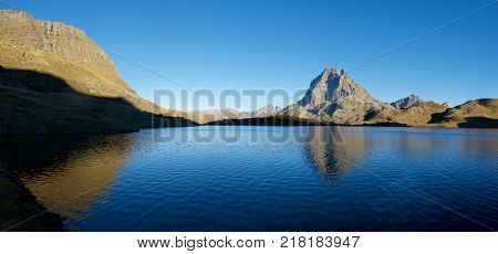Midi Dossau Peak reflected in Gentau lake. Ossau Valley, Pyrenees National Park, Pyrenees, France.
