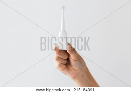 medicine, healthcare and pharmaceutics concept - hand holding tube of micro enema