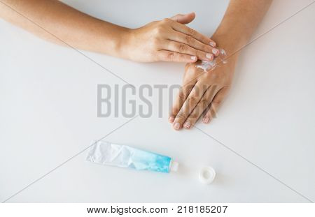 medicine, healthcare and people concept - close up of woman hands applying cream or therapeutic salve
