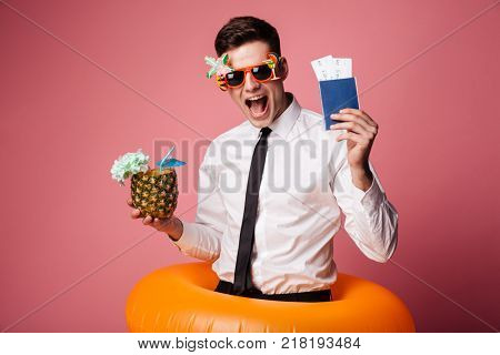 Happy man in sunglasses and official shirt showing cocktail and international passport isolated