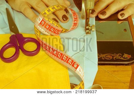 closeup of woman hands sewing yellow cloth outdoors. Woman's Hand Sewing Quilt