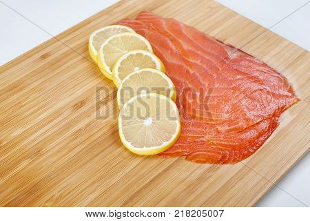 Smoked Fillet salmon with lemon on a board. Seafood.