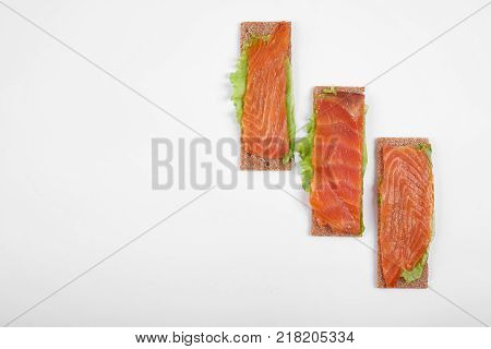 Low caloric open sandwich with red fish. Isolated on white background.