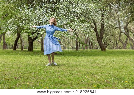 Happy Woman in the Blossoming Spring Garden