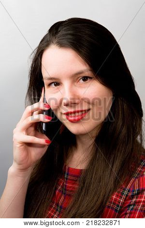 Beautiful girl communicates on the phone. Gadgets.