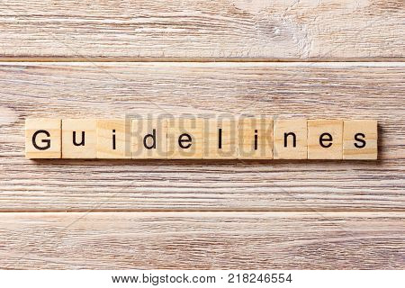 Guidelines word written on wood block. Guidelines text on table concept.