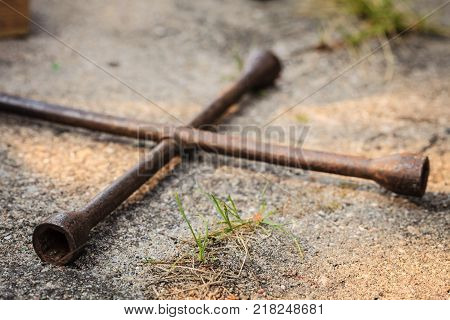 Manual socket wheel wrench lying on ground. Tire car repair objects concept.