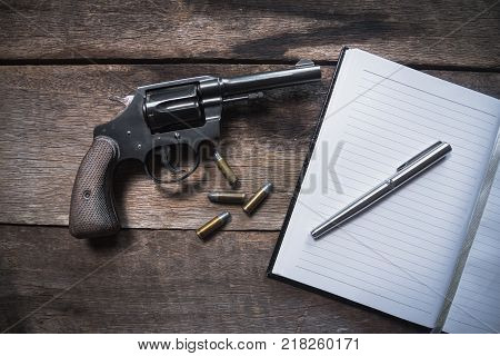 Gun and ammunition on wooden table. top view