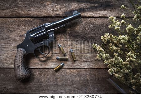 Gun and ammunition on wooden table. top view