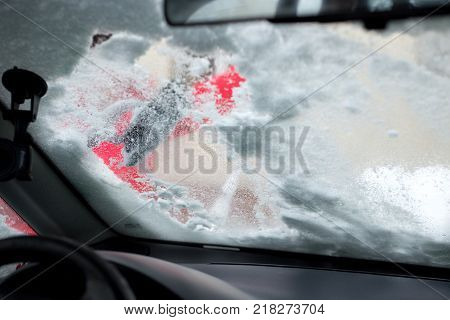 snow-covered window after a snowfall. cleaning the car window after snow
