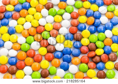 Multicolored background. Bright multicolored background of chocolates. A lot of little pills.