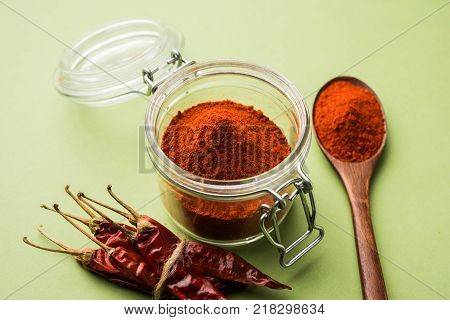 Red Chilly Powder in a bowl with dried red chillies over colourful background or pile of red chilli powder over plain background