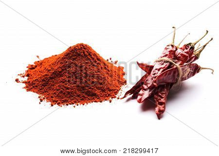 Red Chilly Powder in a bowl with dried red chillies over colourful background or pile of red chilli powder over plain background