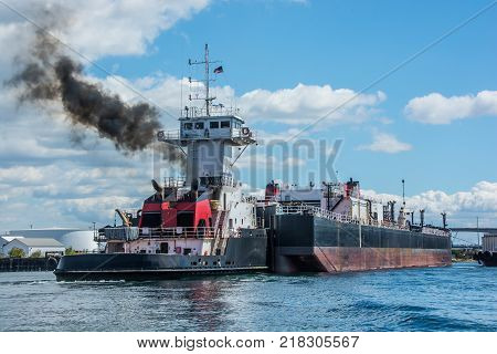 Tug inserted in notch in stern of barge.