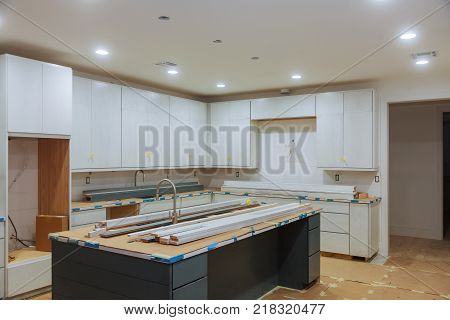 Custom kitchen cabinets in various stages of installation base for island in center Installation of kitchen cabinets