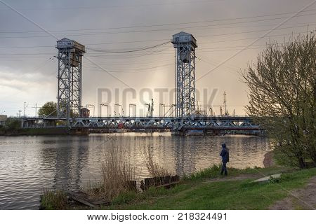 Fisherman near steel double-deck drawbridge over the Pregolya River in Kaliningrad (Konigsberg) Russia. The bridge was built in the 1913-1926 and was reconstructed in 1959-1965.