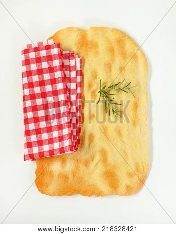 piece of traditional Tuscan flatbread (Ghiottina Toscana) and checkered place mat on white background
