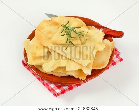 pieces of traditional Tuscan flatbread (Ghiottina Toscana) and kitchen knife on brown plate