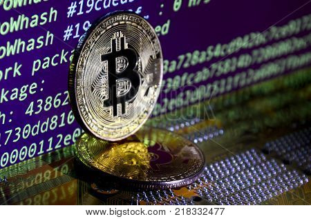 The digital process of cryptocurrency mining by using the GPUs. Bitcoins and video card on a working display and mining screen
