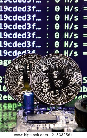 The digital process of cryptocurrency mining by using the GPUs. Bitcoins and video card on a working display and mining screen