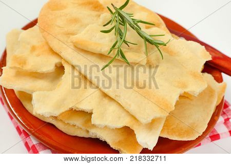 pieces of traditional Tuscan flatbread (Ghiottina Toscana) and kitchen knife on brown plate - close up