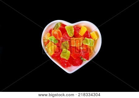 Delicious assorted dried organic fruit in bowl isolated on black background